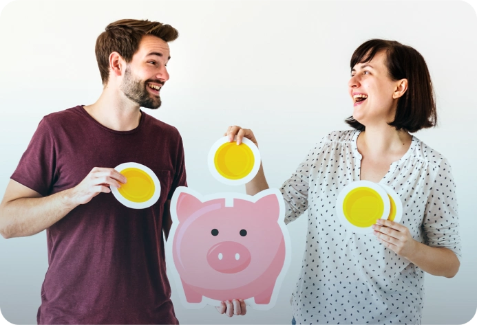 Couple smiling and holding piggy bank