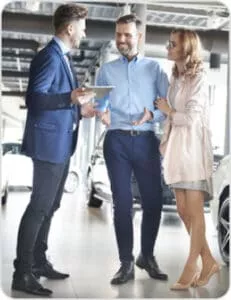 Couple in car dealership talking to a salesman