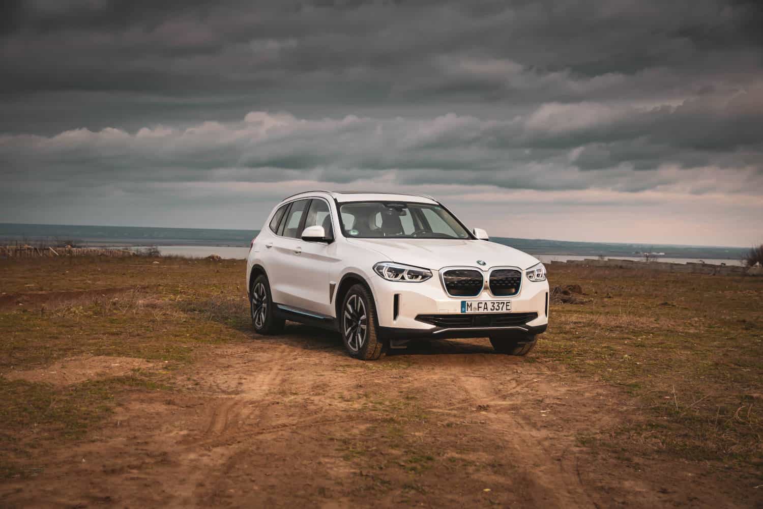 A silver BMW X3 parked against a scenic backdrop, showcasing its sleek design and all-terrain capabilities for winter driving.