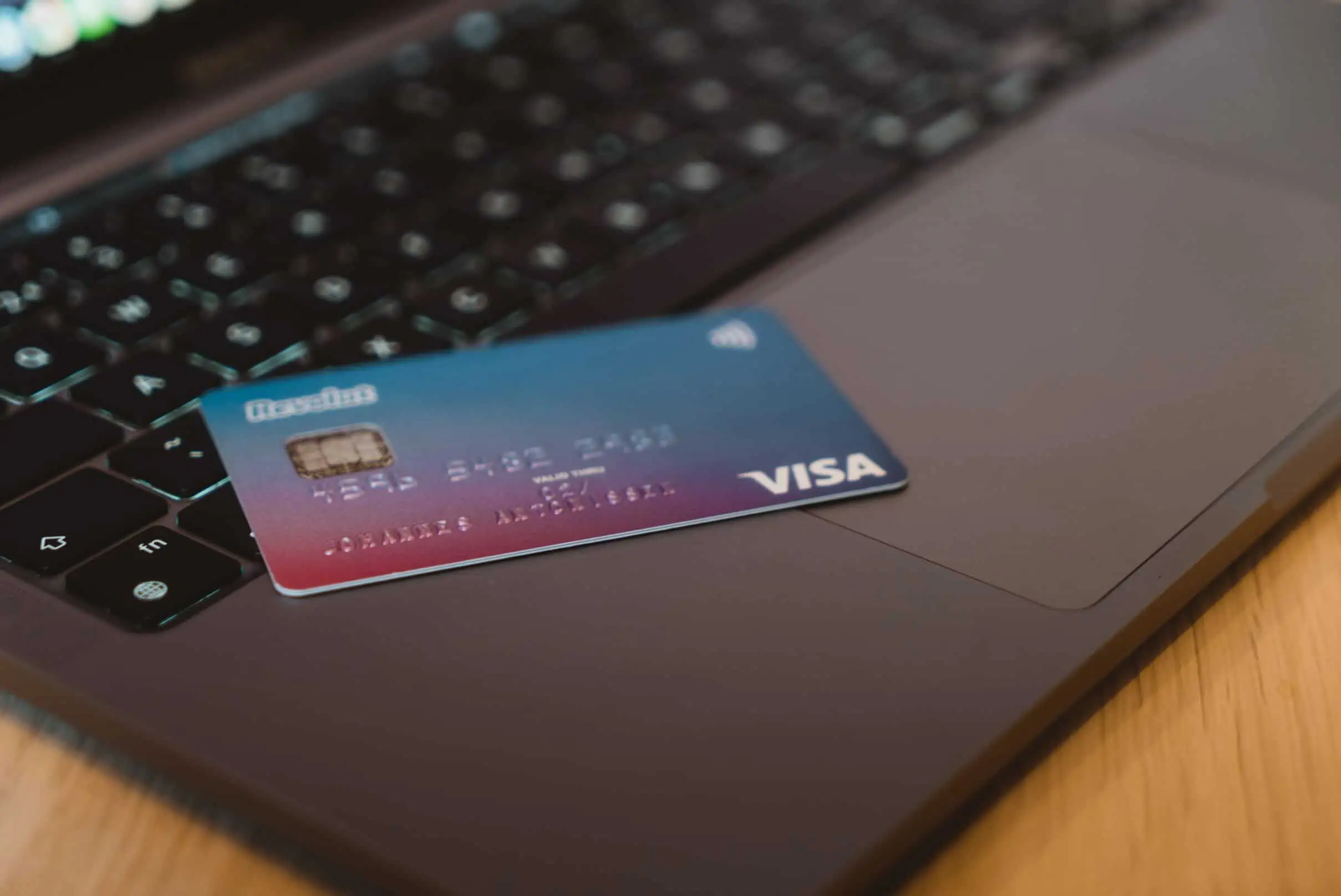 Visual depiction of using a credit card to make a payment for a car finance balloon payment. Card inserted into reader with car and financial elements in the backdrop.