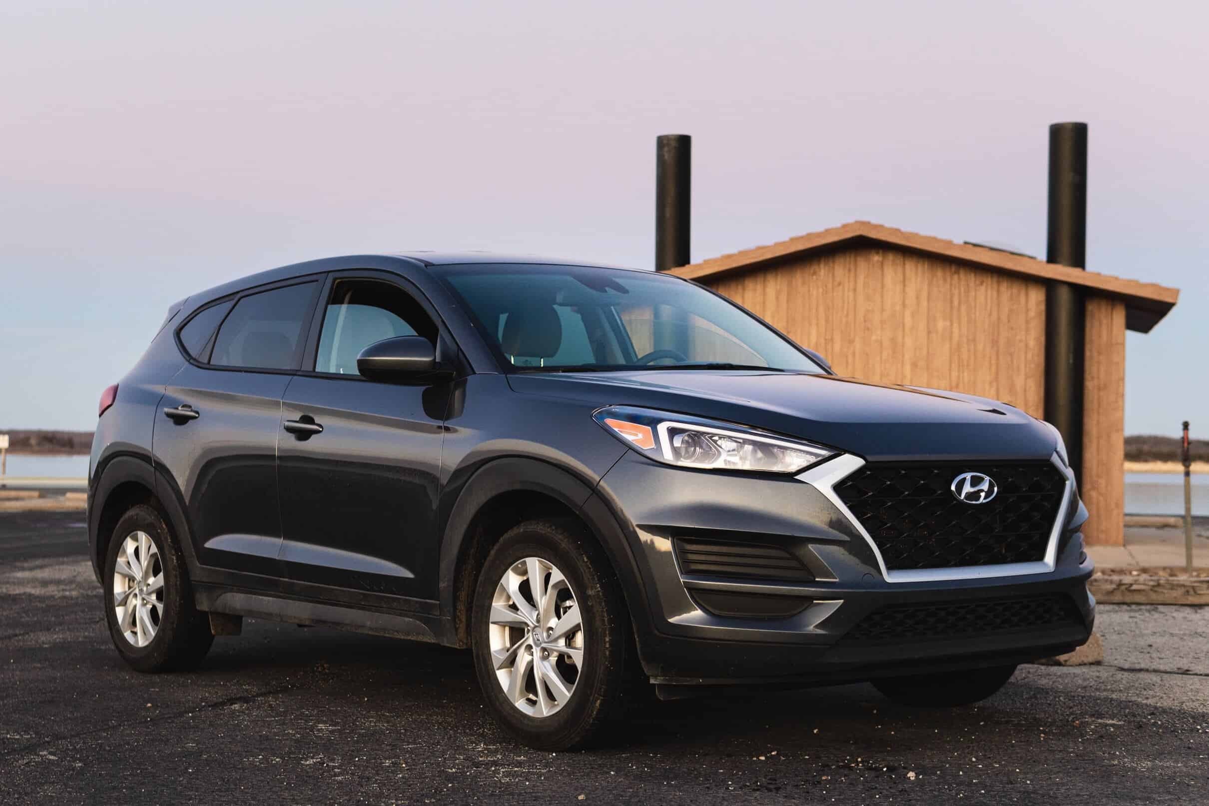 A Hyundai Tucson SUV parked in a scenic countryside landscape.