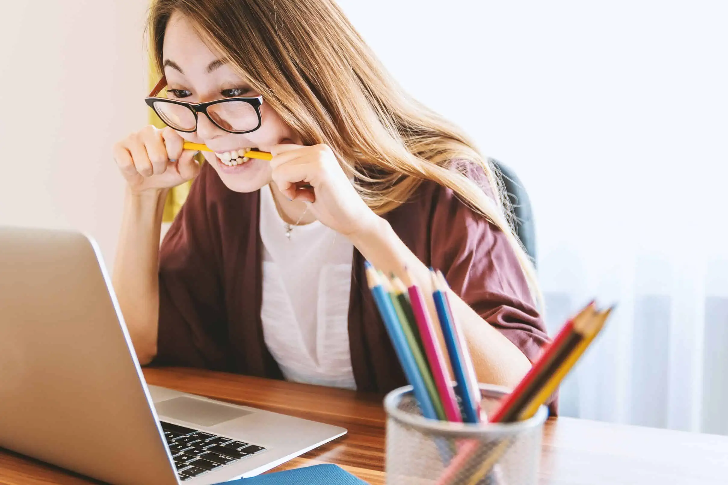 A woman sitting at a desk, looking stressed and concerned while reviewing her poor credit car finance options.