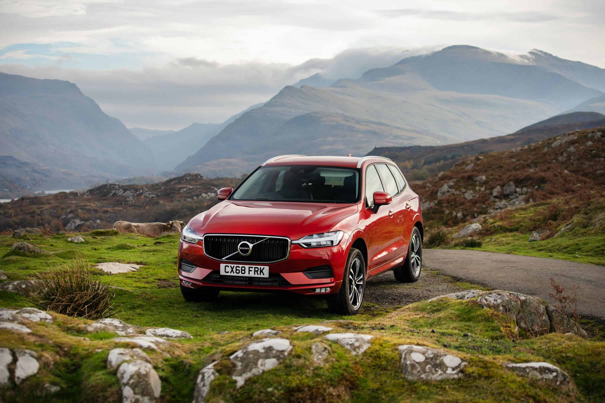 A red Volvo XC60 parked in a scenic setting.