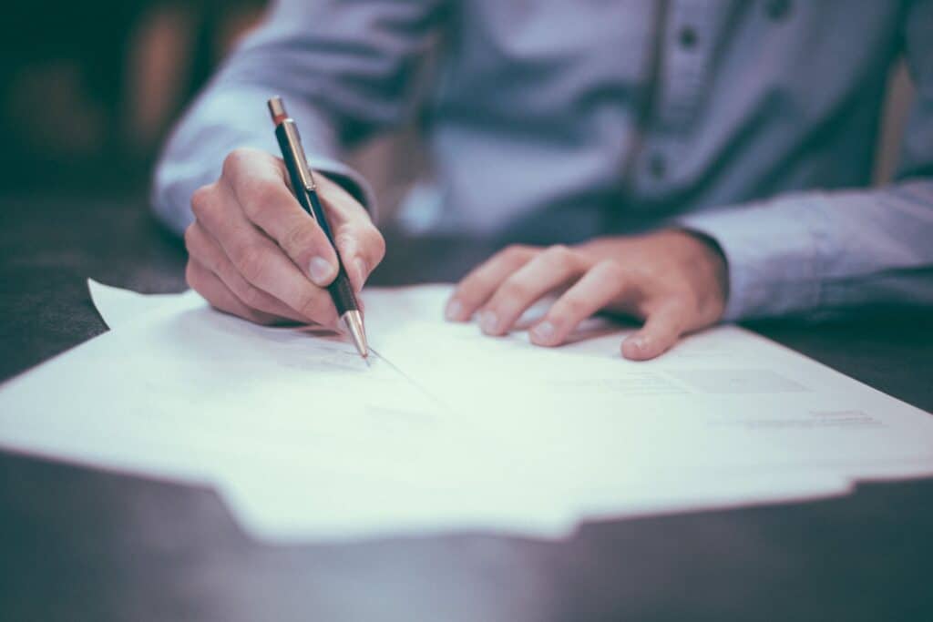 Man signing a car finance contract at dealership