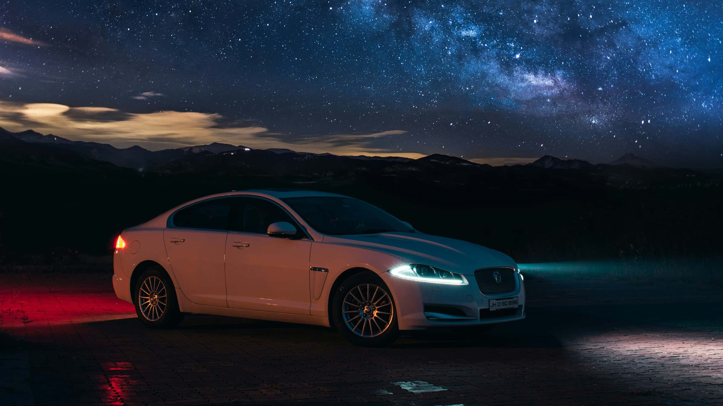 White Jaguar XF gracefully parked under the night sky.